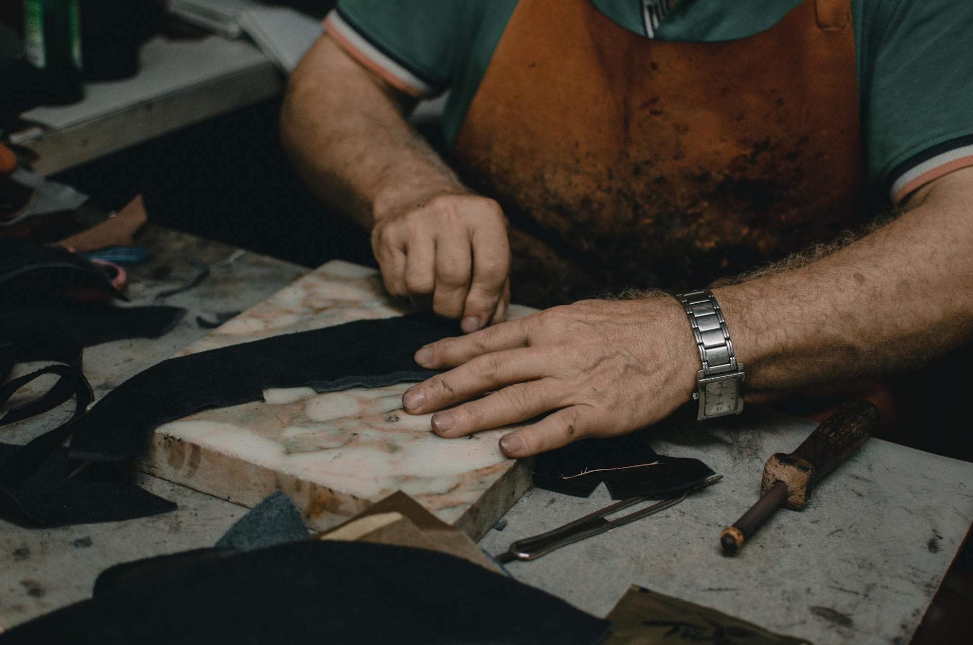 Craftsman cutting leather in a traditional workshop